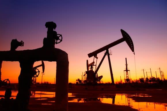 A pipeline and an oil pump at sunset.