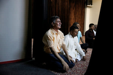 Muslim men attend Eid al-Fitr prayers at a makeshift mosque in a basement, to mark the end of the holy month of Ramadan, in Piraeus, near Athens, Greece July 6, 2016. REUTERS/Alkis Konstantinidis