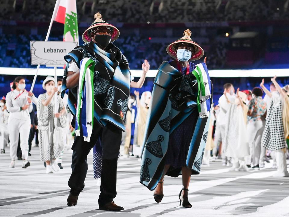 the two members of the lesotho team entering the olympics opening ceremony 2021