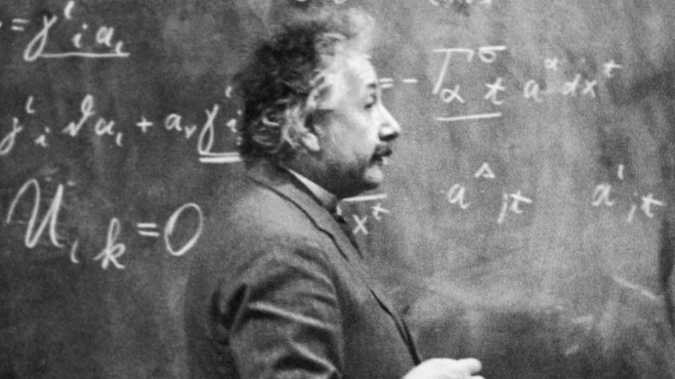 Einstein en 1931 dando clase frente a una pizarra llena de ecuaciones.