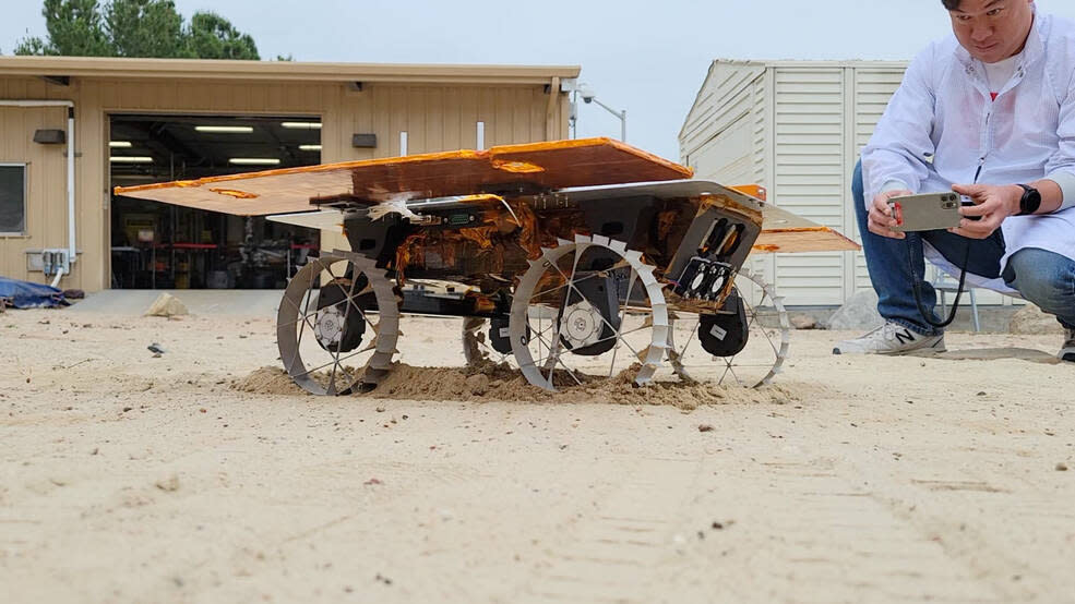  a small four-wheeled rover travels across sand in a test yard at nasa's jet propulsion laboratory. 