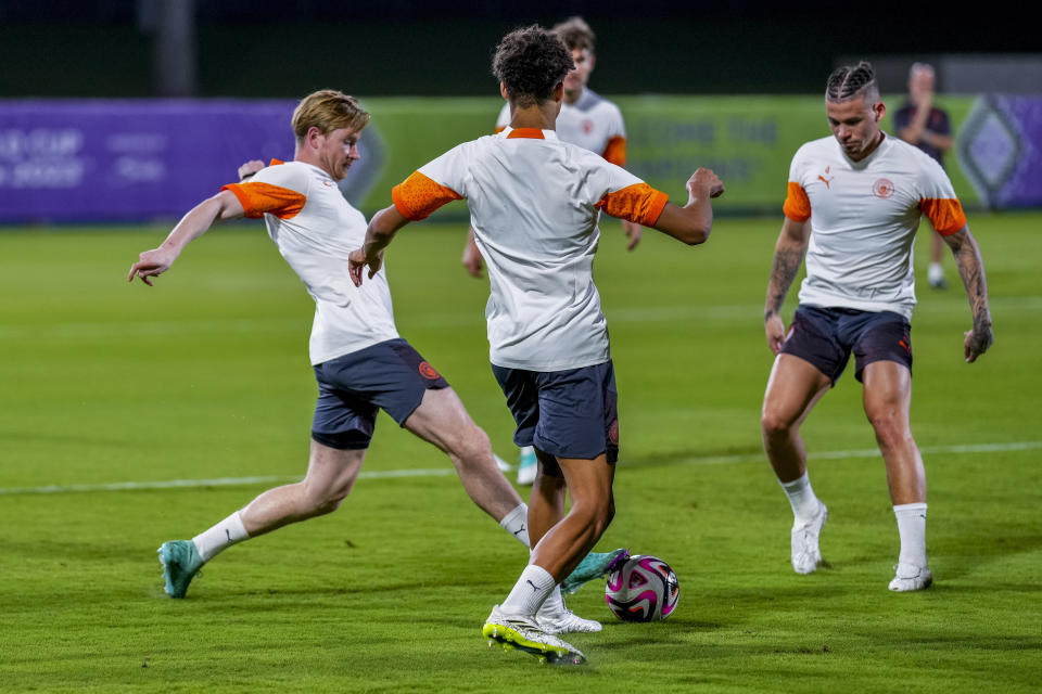 Manchester City's Kevin de Bruyne, left, plays with a bull with his teammates during a training session at the King Abdullah Sports City Stadium in Jeddah, Saudi Arabia, Thursday, Dec. 21, 2023. Manchester City will play against Fluminense during the final soccer match of the Club World Cup on Friday Dec. 21. (AP Photo/Manu Fernandez)