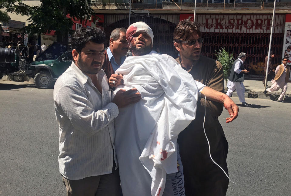 <p>People carry an injured man after a suicide attack in Kabul, Afghanistan, Wednesday, May 31, 2017. (AP Photo/Rahmat Gul) </p>