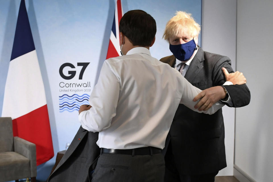 Britain's Prime Minister Boris Johnson, right, greets French President Emmanuel Macron ahead of a bilateral meeting during the G7 summit in Cornwall, England, Saturday June 12, 2021. (Stefan Rousseau/Pool via AP)