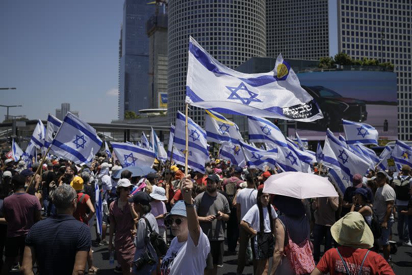 Demonstrators wave Israeli flags during a protest in Tel Aviv marking nine months since the start of the war in Gaza, July 7, 2024