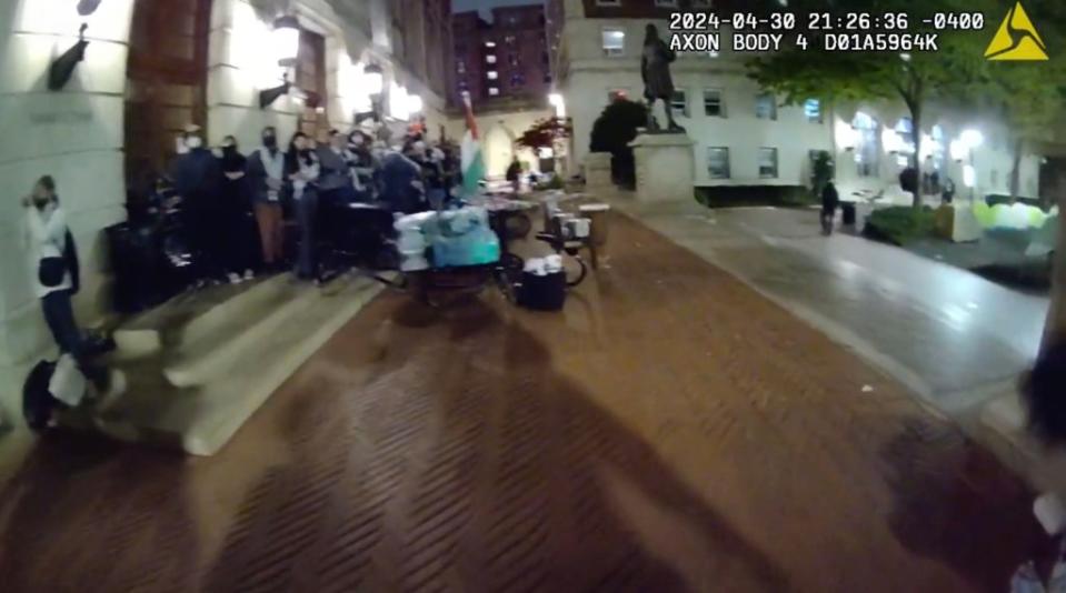 A group of protesters surrounded by metal tables and trash cans made up the first layer of the barricade. New York City Police Department