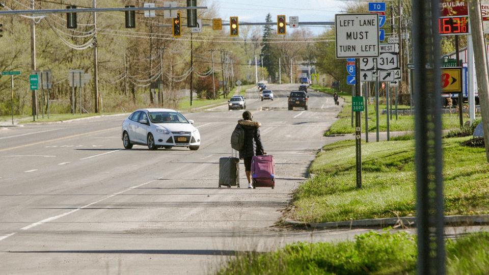 A woman from the Democratic Republic of Congo, with luggage in tow, tried to call family. She tried to enter Canada at Roxham Road, only to find out it had been closed. After some time waiting, the Congolese woman rolled her suitcase down the country road.
