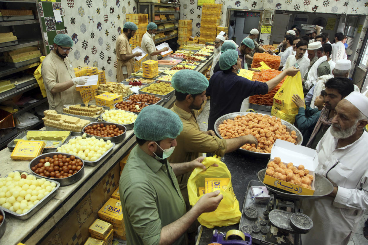 People buy sweets at a shop in preparation for the upcoming Eid al-Fitr celebrations, in Peshawar, Pakistan, Sunday, May 1, 2022. (AP Photo/Mohammad Sajjad)