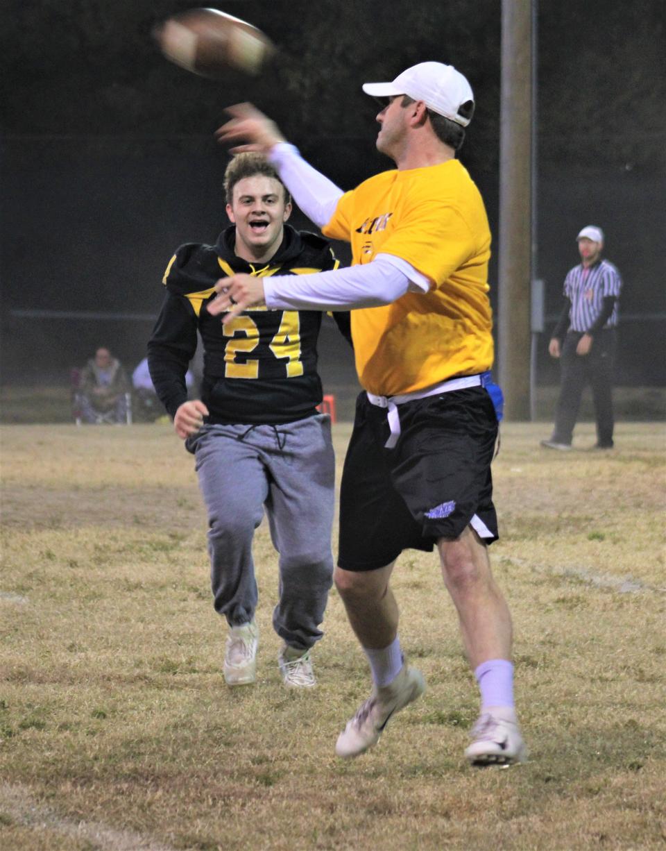 Bellevue's Landon Corley pressures QB Trevor Stellman as Bellevue's varsity football team played a flag football game Friday against members of the Bellevue police department and other adult members of the community after their season was canceled due to a lack of available players.