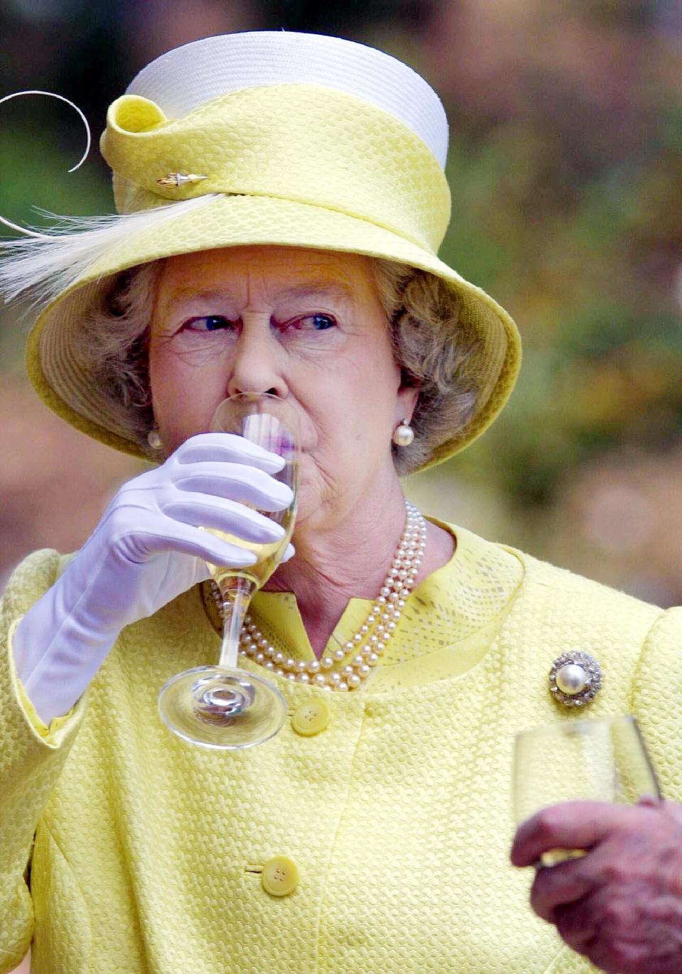 Queen Elizabeth II of Britain sampliesa Barrosa wine while visiting Chateau Barrosa in Adelaide during her golden jubilee tour, 28 February 2002. (Photo by AFP / POOL / AFP)        (Photo credit should read AFP/AFP via Getty Images)