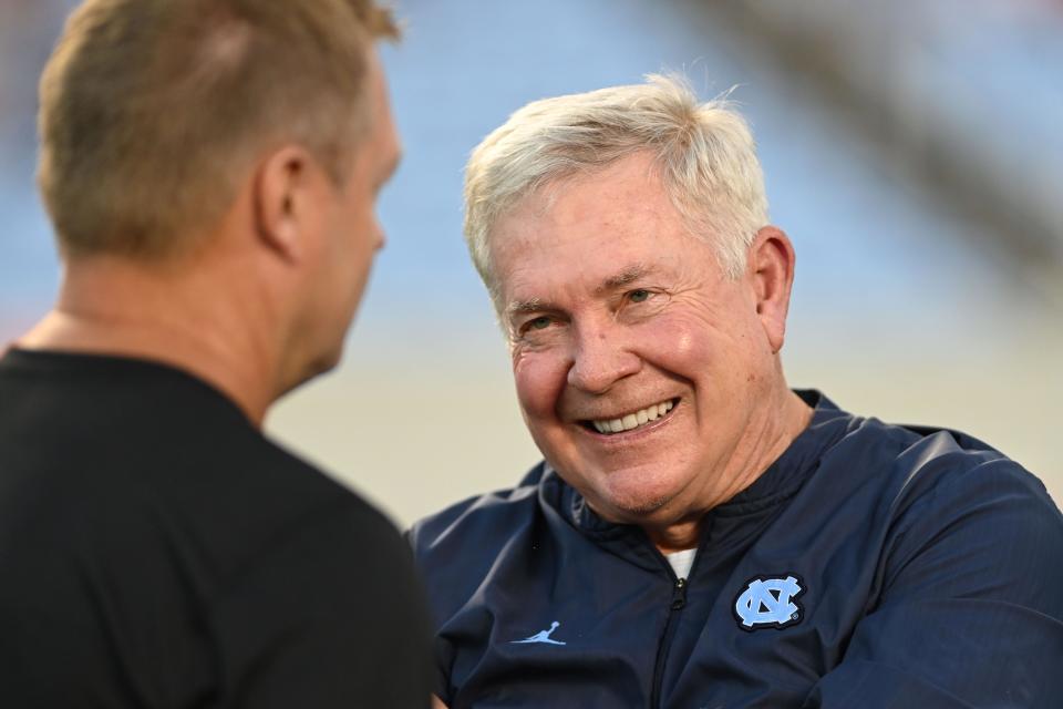 North Carolina coach Mack Brown, right, chats with Virginia coach Bronco Mendenhall before the Tar Heels’ victory in September at Kenan Stadium.