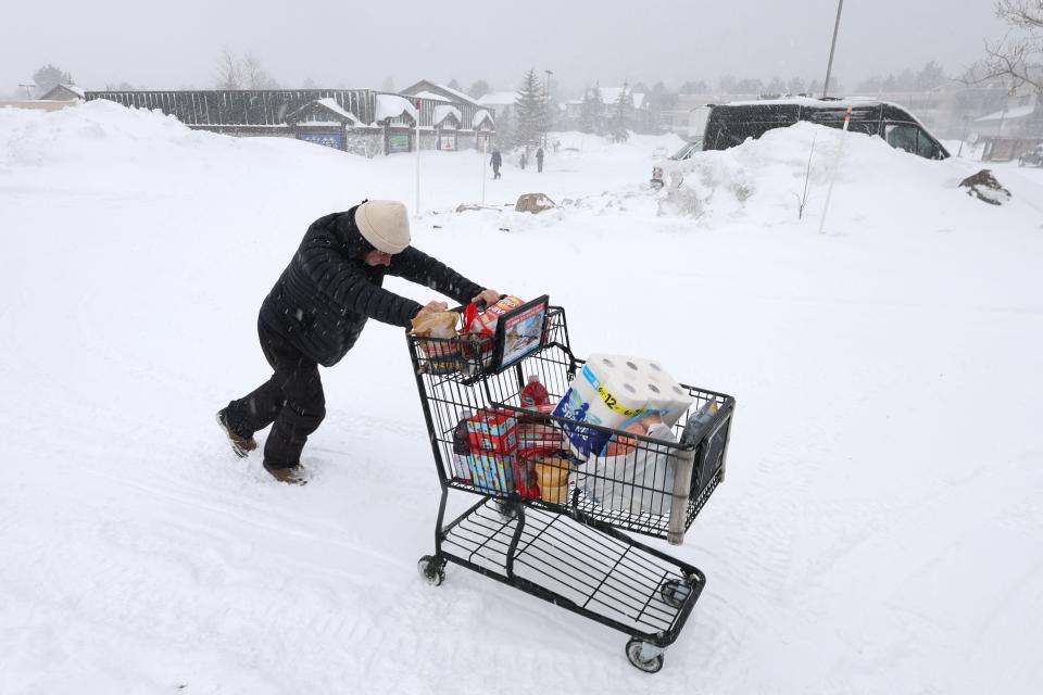 A customer pushes their grocery cart through the snow to their car as a blizzard hits Mammoth Lakes, California, on March 2, 2024. The National Weather Service has issued a blizzard warning for California's entire Sierra Nevada through early March 3, 2024. Forecaster report the storm could bring three to five inches (8 to 13cms) of snow per hour. (Photo by DAVID SWANSON / AFP) (Photo by DAVID SWANSON/AFP via Getty Images) ORG XMIT: 776114505 ORIG FILE ID: 2046560684