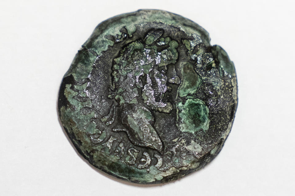 A rare, nearly 1,850-year-old bronze coin discovered off the Israeli coastal city of Haifa is on display at Israel's Antiquities Authority office in Jerusalem, Tuesday, July 26, 2022. The coin on one side bears the image of the zodiac sign Cancer behind a depiction of the moon goddess Luna. Experts said Monday the coin was minted in Alexandria, Egypt, under the rule of the Roman Emperor Antoninus Pius in the second century. The antiquities authority says it is the first time such a coin has been found off the Israeli coast. (AP Photo/Tsafrir Abayov)