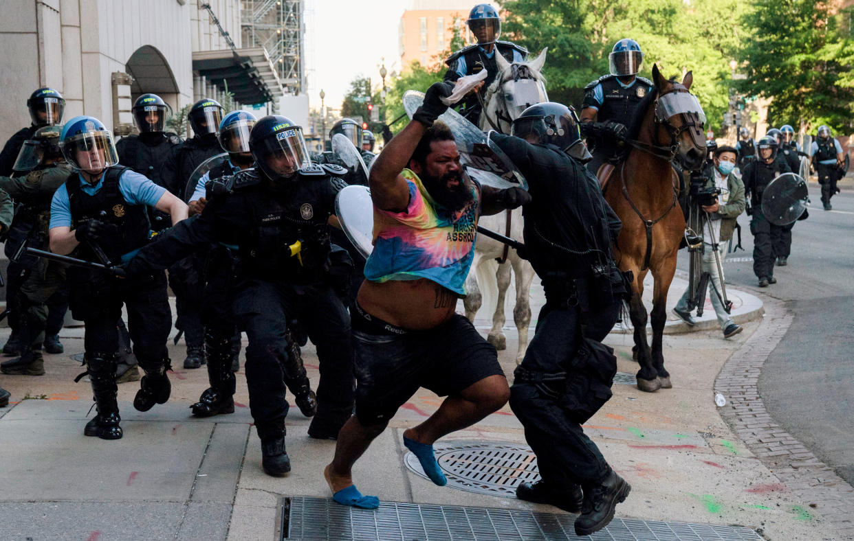 Riot police chase a man 