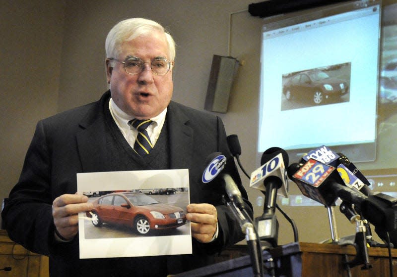 Former Bucks County DA, David Heckler, holds a photo during a press conference of a red Nissan that is suspected to be involved in the murder of Joseph Canazaro of Hilltown on Jan. 18, 2013.