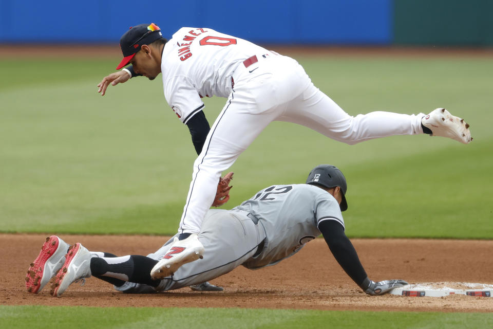 Chicago White Sox's Kevin Pillar (12) dives safely back to second base during a pick off attempt as Cleveland Guardians second baseman Andrés Giménez (0) attempts a tag during the first inning of a baseball game, Tuesday, April 9, 2024, in Cleveland. (AP Photo/Ron Schwane)