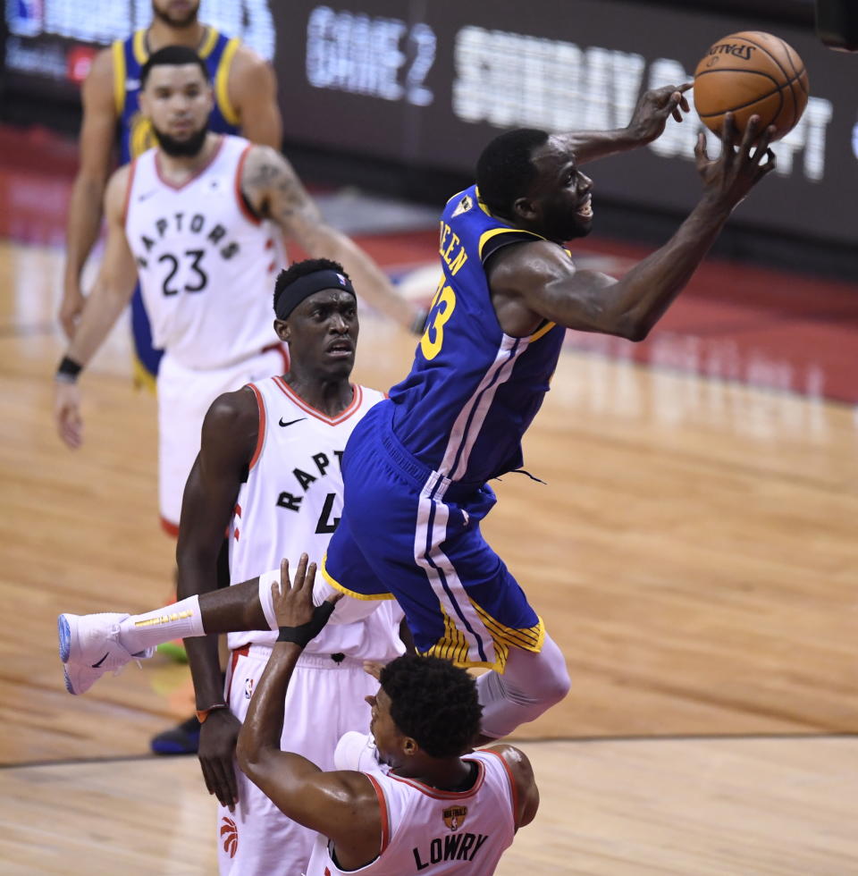 Golden State Warriors forward Draymond Green (23) commits an offensive foul on Toronto Raptors guard Kyle Lowry (7) during the first half of Game 1 of basketball's NBA Finals, Thursday, May 30, 2019, in Toronto. (Frank gunn/The Canadian Press via AP)