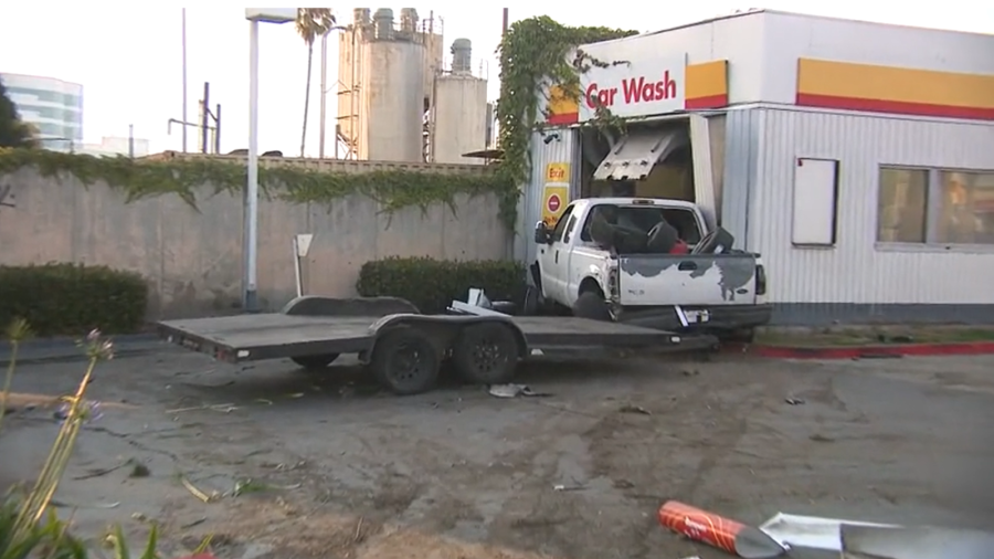 A violent hit-and-run crash involving two trucks caused heavy damage to a gas station car wash in Harbor Gateway on July 16, 2024. (KTLA)