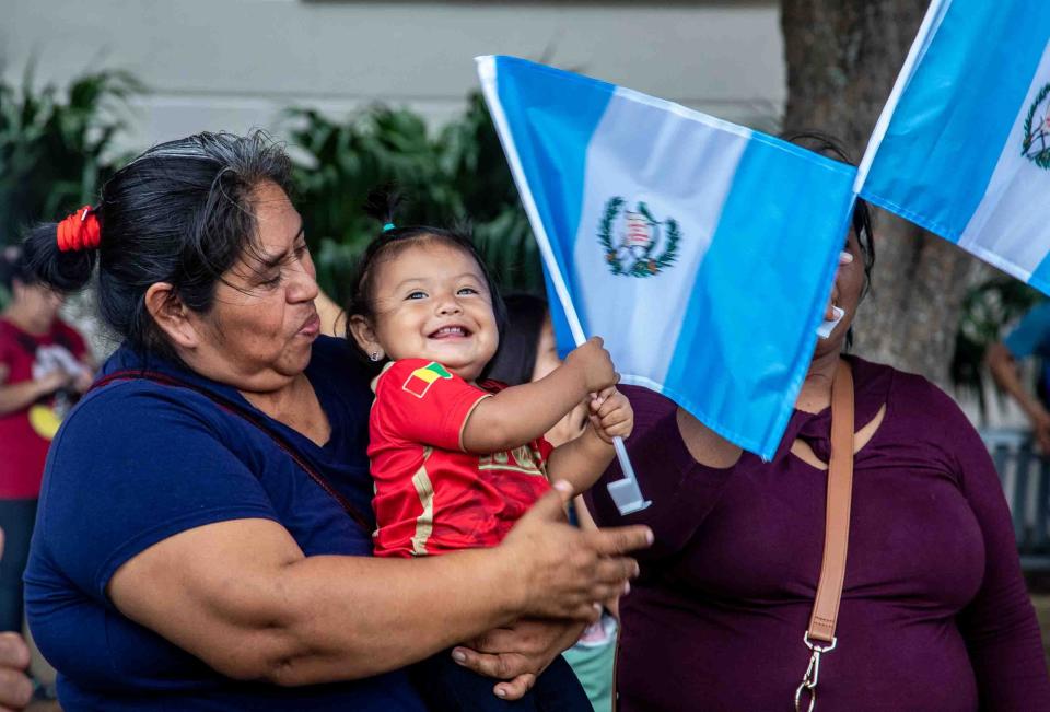 A baby holds the flag of Guatemala on Sunday during rally at Lake Worth Beach City Hall to protest Florida's new immigration law.