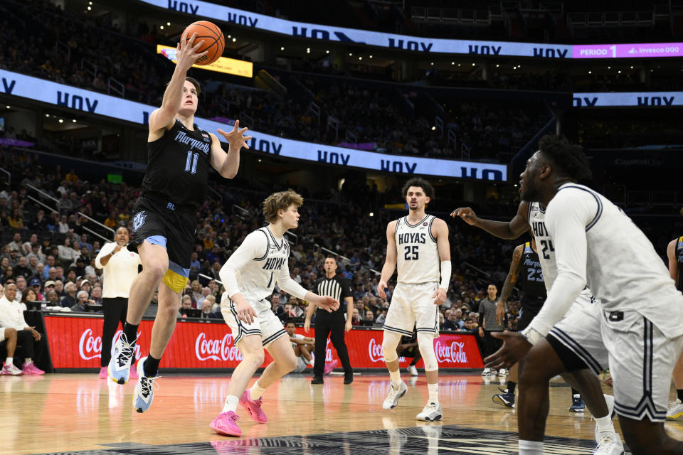 Marquette guard Tyler Kolek (11) goes to the basket past Georgetown guard Rowan Brumbaugh (1) and forward Ismael Massoud (25) during the first half of an NCAA college basketball game, Saturday, Feb. 3, 2024, in Washington. (AP Photo/Nick Wass)