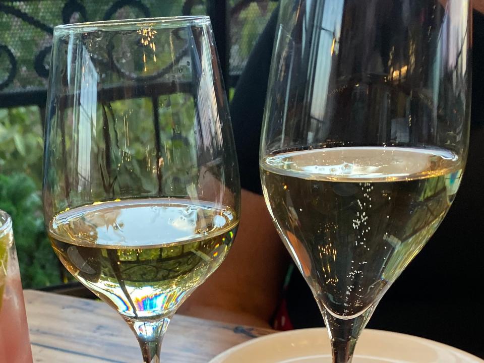a cocktail, two glasses of wine, and a plate of meatballs at wine bar george in disney springs