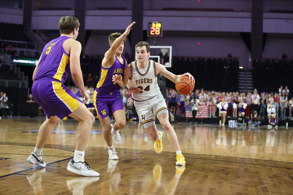 Harrisburg's Jacoby Mehrman drives to the basket against Watertown's Will Engstrom and Caden Beauchamp (5) during their opening-round game in the state Class AA boys basketball tournament on Thursday, March 14, 2024 in the Denny Sanford PREMIER Center at SIoux Falls. Harrisburg won 71-56.