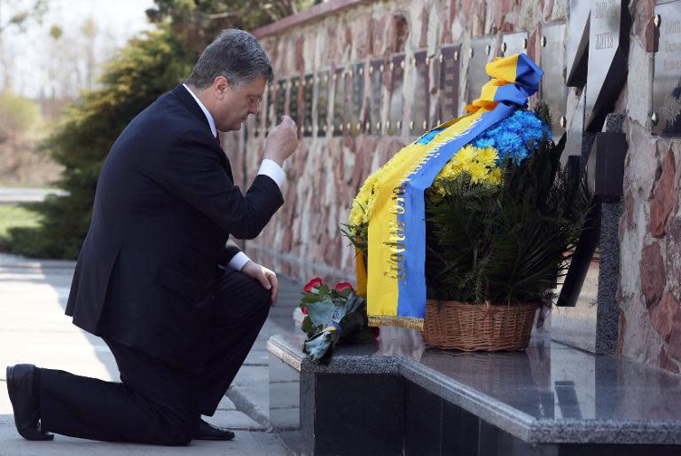 A handout picture taken and released on April 26, 2015 by the Ukrainian presidential press service shows President Petro Poroshenko laying flowers at the memorial in front of the Chernobyl plant