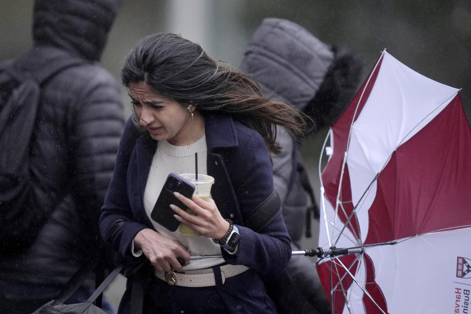 A passer-by carries an umbrella while walking in strong wind, Thursday, April 4, 2024, in Boston. A spring storm is bringing heavy rain and high winds across New England. (AP Photo/Steven Senne)