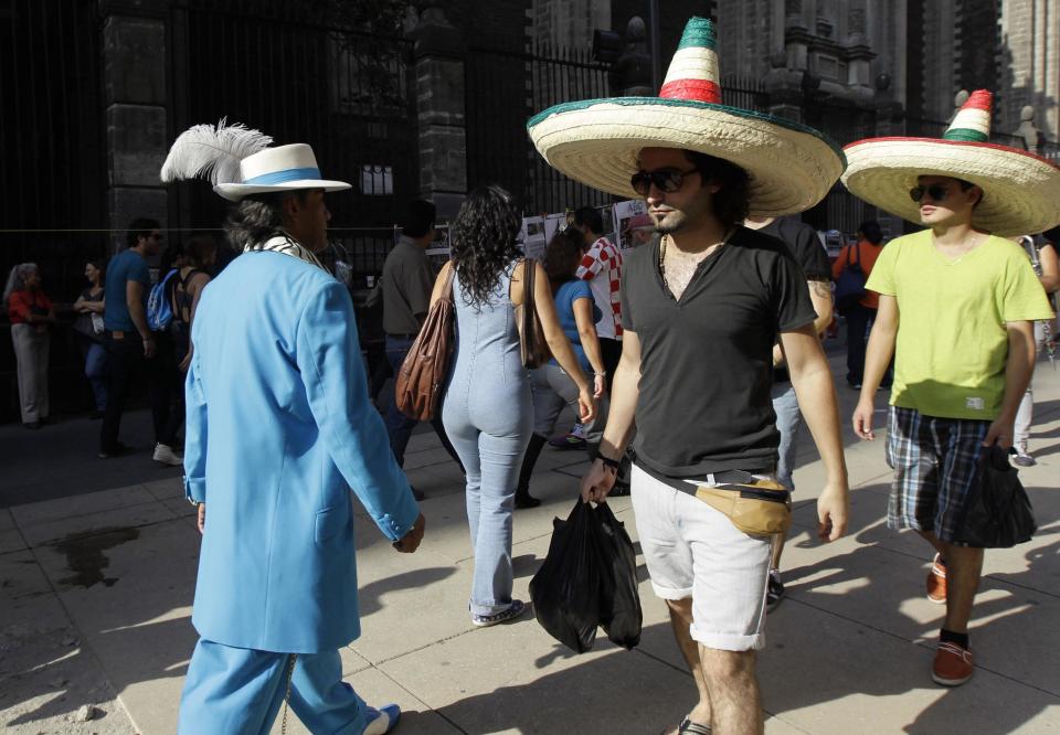 Jesus Gonzalez de la Rosa, dressed in "Pachuco" style,walks past tourists in Mexico City