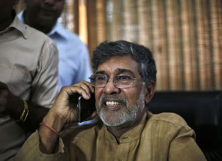 Children's right activist Kailash Satyarthi speaks on his mobile phone at his office in New Delhi October 10, 2014. REUTERS/Adnan Abidi