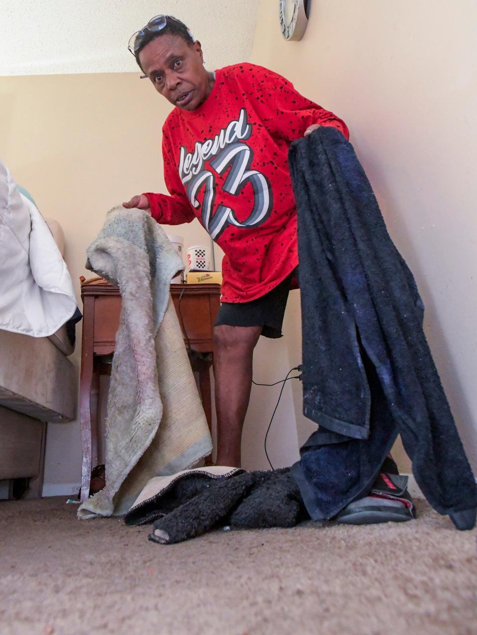 Bernetta Harris uses towels to soak up water flowing into her apartment at Brentwood Estates in Montgomery on Jan. 24.