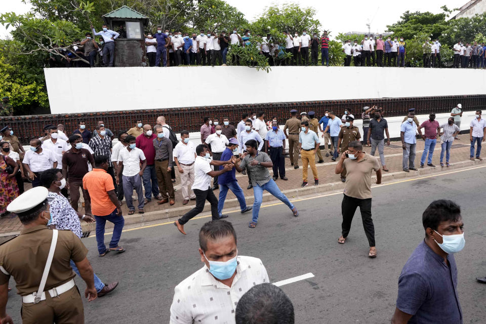 A Sri Lankan government supporter, center left in white shirt, attacks an anti-government protester during clashes outside prime minister's residence in Colombo, Sri Lanka, Monday, May 9, 2022. Authorities deployed armed troops in the capital Colombo on Monday hours after government supporters attacked protesters who have been camped outside the offices of the country's president and prime minster, as trade unions began a “Week of Protests” demanding the government change and its president to step down over the country’s worst economic crisis in memory. (AP Photo/Eranga Jayawardena)