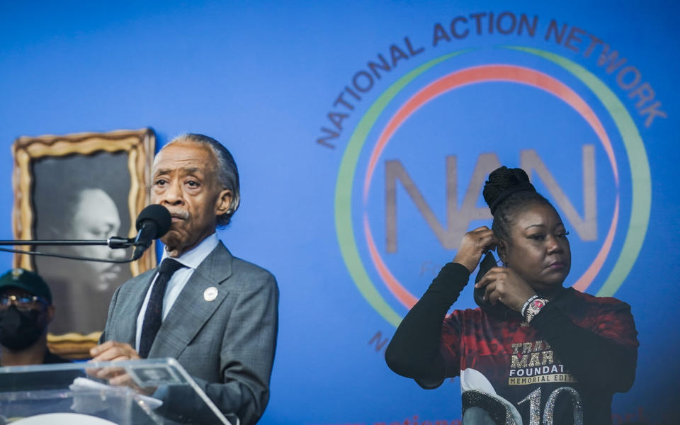 Sybrina Fulton, right, prepares her mask as Rev. Al Sharpton, center, president of National Action Network (NAN), speaks during a rally commemorating the 10th anniversary of the killing of her son Trayvon Martin, Saturday Feb. 26, 2022, at NAN's Harlem headquarters in New York. "Today is a bittersweet day," said Fulton, who with her family created the Trayvon Martin Foundation to raise awareness of gun violence. (AP Photo/Bebeto Matthews)
