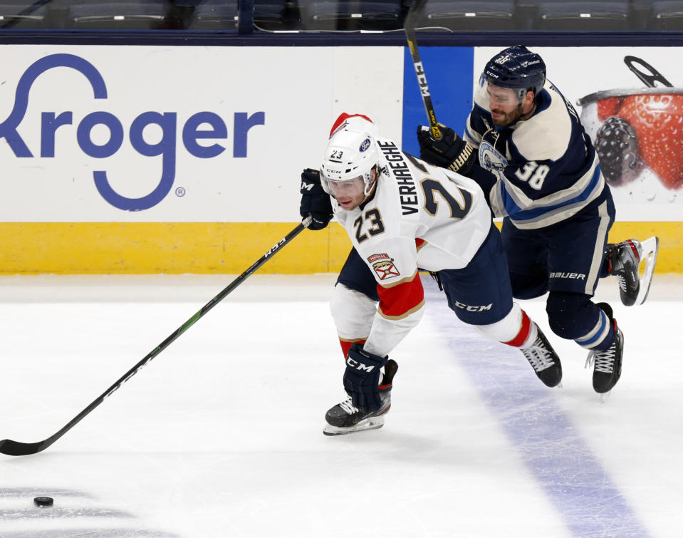 Florida Panthers forward Carter Verhaeghe, left, controls the puck next to Columbus Blue Jackets forward Boone Jenner during the first period of an NHL hockey game in Columbus, Ohio, Tuesday, Jan. 26, 2021. (AP Photo/Paul Vernon)