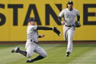 New York Yankees' Brett Gardner, left, tries to catch a ball hit by Cleveland Indians' Cesar Hernandez in the first inning of a baseball game, Thursday, April 22, 2021, in Cleveland. Gardner could not hold onto the ball for the out and Hernandez was safe with a single. (AP Photo/Tony Dejak)