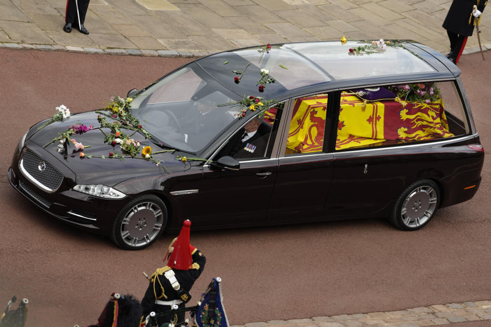 The hearse carrying the coffin of Queen Elizabeth II arrives at Windsor castle, Britain, Monday, Sept. 19, 2022. The Queen, who died aged 96 on Sept. 8, will be buried at Windsor alongside her late husband, Prince Philip, who died last year. (AP Photo/Kirsty Wigglesworth, Pool)