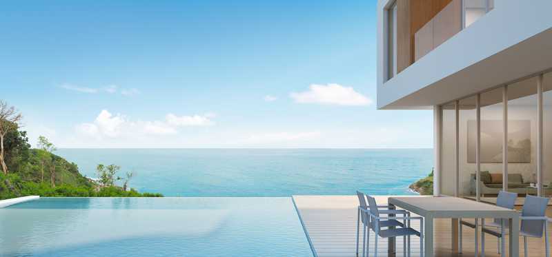 A house with a pool overlooks the beach