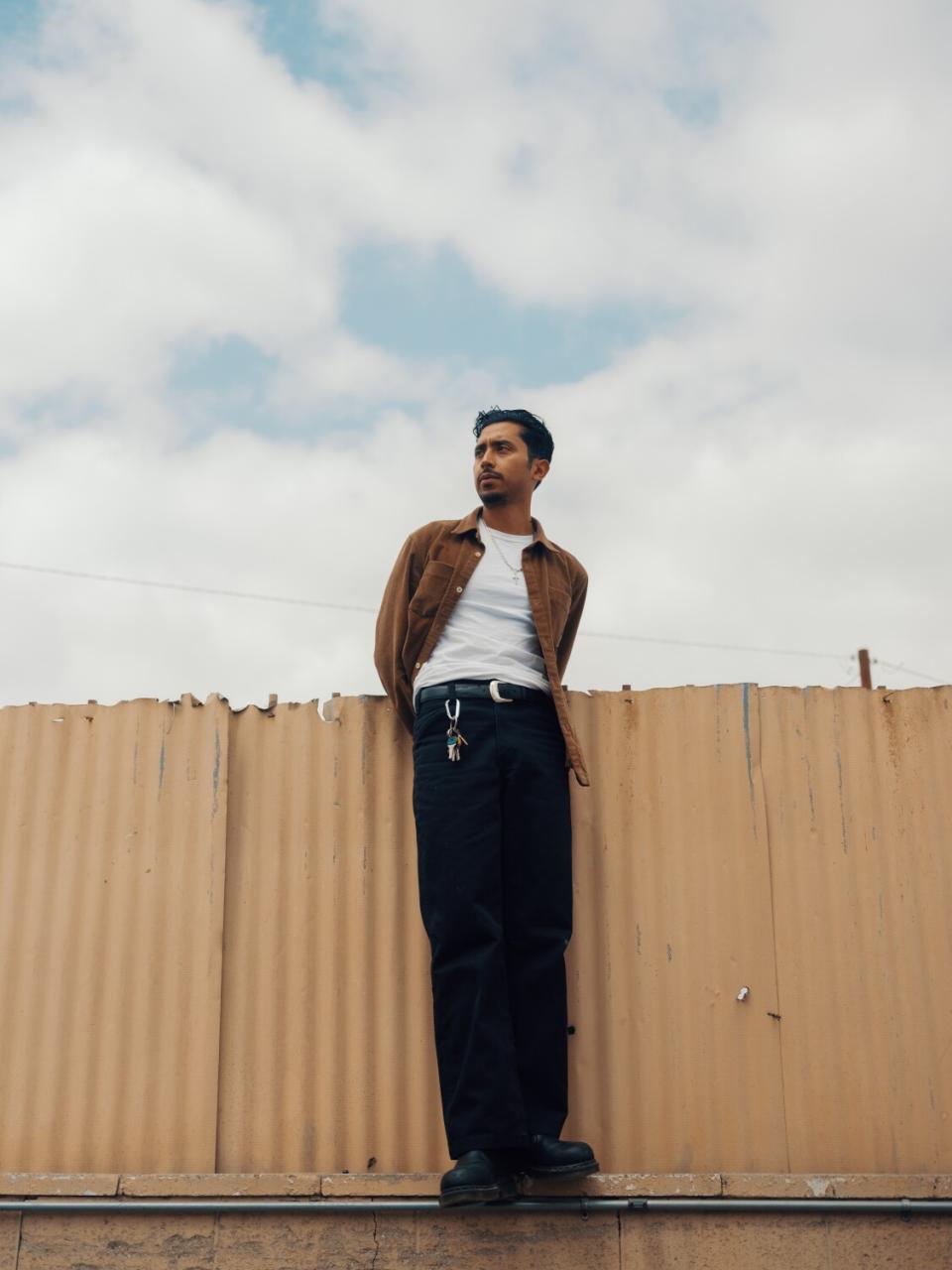 Preciado stands on the fence at Jose Auto Body Shop.