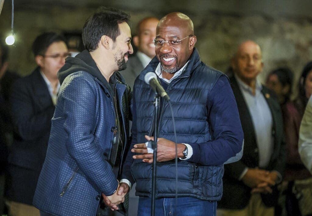 Composer Lin-Manuel Miranda, left, and Georgia incumbent Democratic Sen. Raphael Warnock shake hands at a Latino voter rally in Atlanta on Wednesday, Oct 19, 2021. Miranda is one of a number of celebrities trying to sway voters, although it’s unclear how much influence they have. (Arvin Temkar/Atlanta Journal-Constitution via AP)
