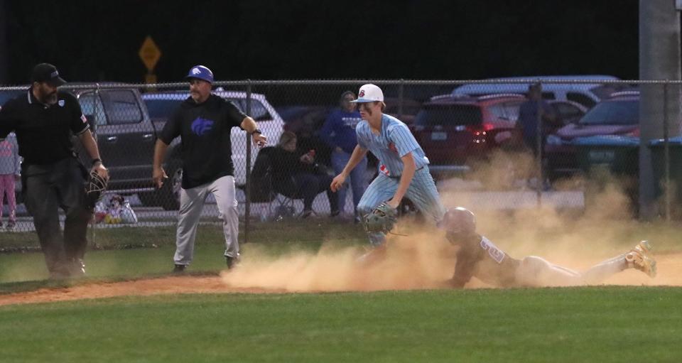 Deltona's Jaden Colon (20) slides into third in a big cloud of dust as Seabreeze's Brody Harris (9) races after the loose ball during the District 5-5A semifinals, Tuesday, April 30, 2024, at the Ormond Beach Sports Complex.