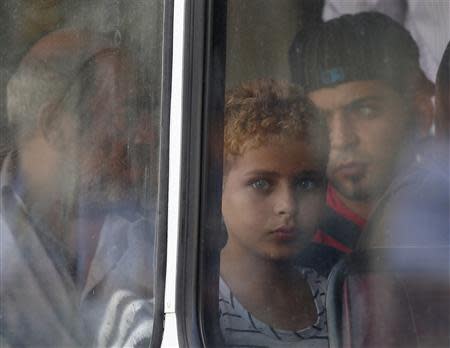 A rescued migrant child looks out of the window of a police bus after arriving at the Armed Forces of Malta Maritime Squadron base at Haywharf in Valletta's Marsamxett Harbour October 12, 2013. REUTERS/Darrin Zammit Lupi