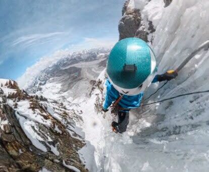 A climbers helmet seen from above, as he climbs on vertical water ice