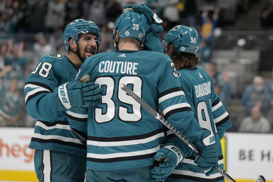 San Jose Sharks center Logan Couture, middle, is congratulated by defenseman Mario Ferraro, left, and left wing Alexander Barabanov after scoring against the Seattle Kraken during the second period of an NHL hockey game in San Jose, Calif., Monday, Feb. 20, 2023. (AP Photo/Jeff Chiu)