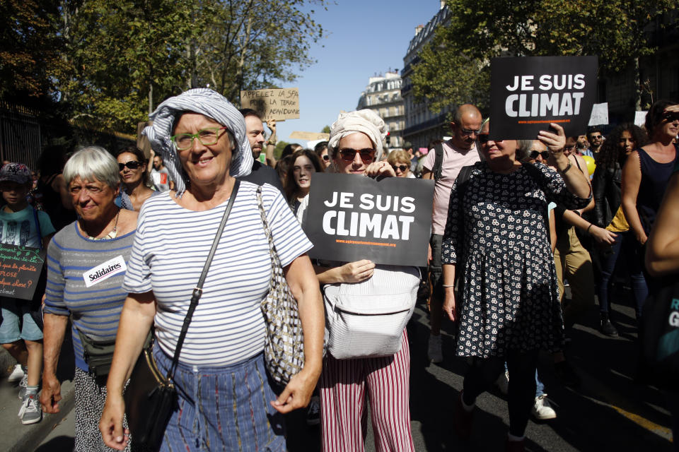 Protestors hols boards reading "I am climate" during a climate demonstration, in Paris, Saturday, Sept. 21, 2019. Scuffles broke out in Paris between some violent activists and police which responded with tear gas at a march for climate gathering thousands of people in Paris. (AP Photo/Thibault Camus)