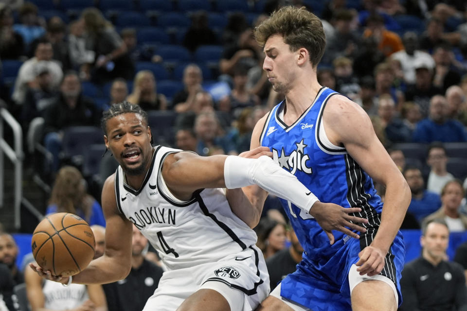 Brooklyn Nets guard Dennis Smith Jr. (4) makes a move to get past Orlando Magic forward Franz Wagner during the first half of an NBA basketball game Wednesday, March 13, 2024, in Orlando, Fla. (AP Photo/John Raoux)