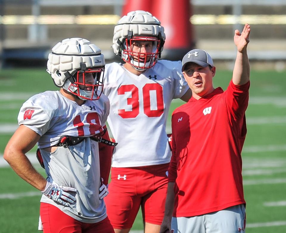 Wisconsin safeties Collin Wilder (18) and Tyler Mais work with defensive coordinator Jim Leonhard at practice Friday, August 13, 2021, at Camp Randall Stadium in Madison, Wisconsin.