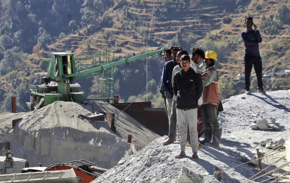 Peoeple watch rescue operations at the site of an under-construction road tunnel that collapsed trapping 41 workers in Silkyara in the northern Indian state of Uttarakhand, Wednesday, Nov. 22, 2023. The workers have been trapped for over a week, as rescuers work on an alternate plan of digging toward them vertically. (AP Photo)