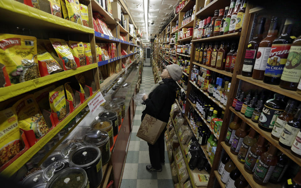 In this Nov. 21, 2013 photo, a woman surveys the shelves in an aisle of Kalustyan's Indian/Middle Eastern spice and specialty food shop in New York. The not-so-little gem of a shop nestled into a row of like-minded stores on Lexington Avenue is known to New Yorker foodies, but off the map for most tourists. (AP Photo/Richard Drew)