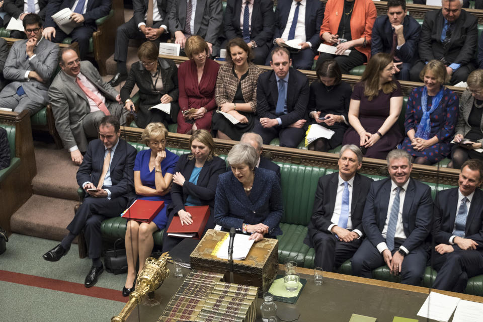 Backdropped by members of the ruling Conservative Party, Britain's Prime Minister Theresa May, centre, stands as she speaks during the regular scheduled Prime Minister's Questions inside the House of Commons in London, Wednesday Dec. 12, 2018. May has confirmed there will be a vote of confidence in her leadership of the Conservative Party, later Wednesday, with the result expected to be announced soon after. (Mark Duffy/UK Parliament via AP)