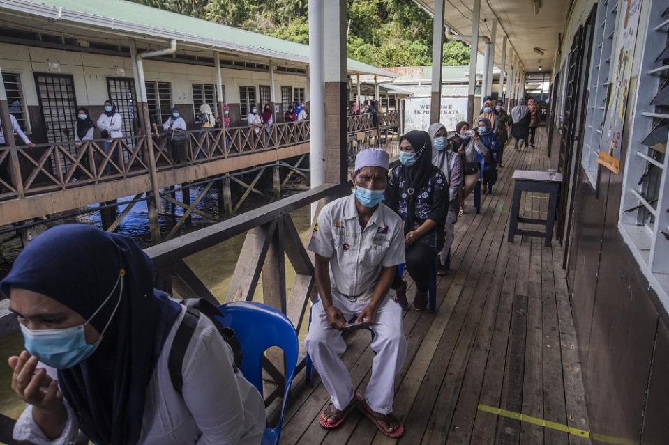 Voters wearing protective masks queue up to cast their votes during the Sabah state election in SK Pulau Gaya September 26, 2020. — Pictures by Firdaus Latif